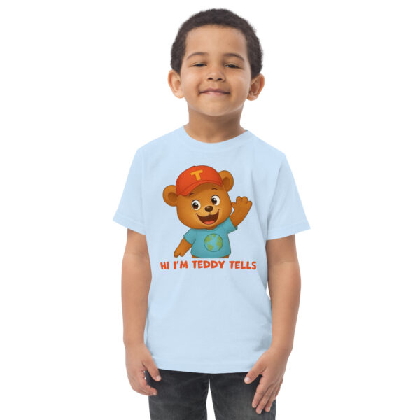 Teddy Tells Light Blue Toddler T-Shirt Front Teddy Tells light blue toddler t-shirt front featuring a friendly teddy bear character